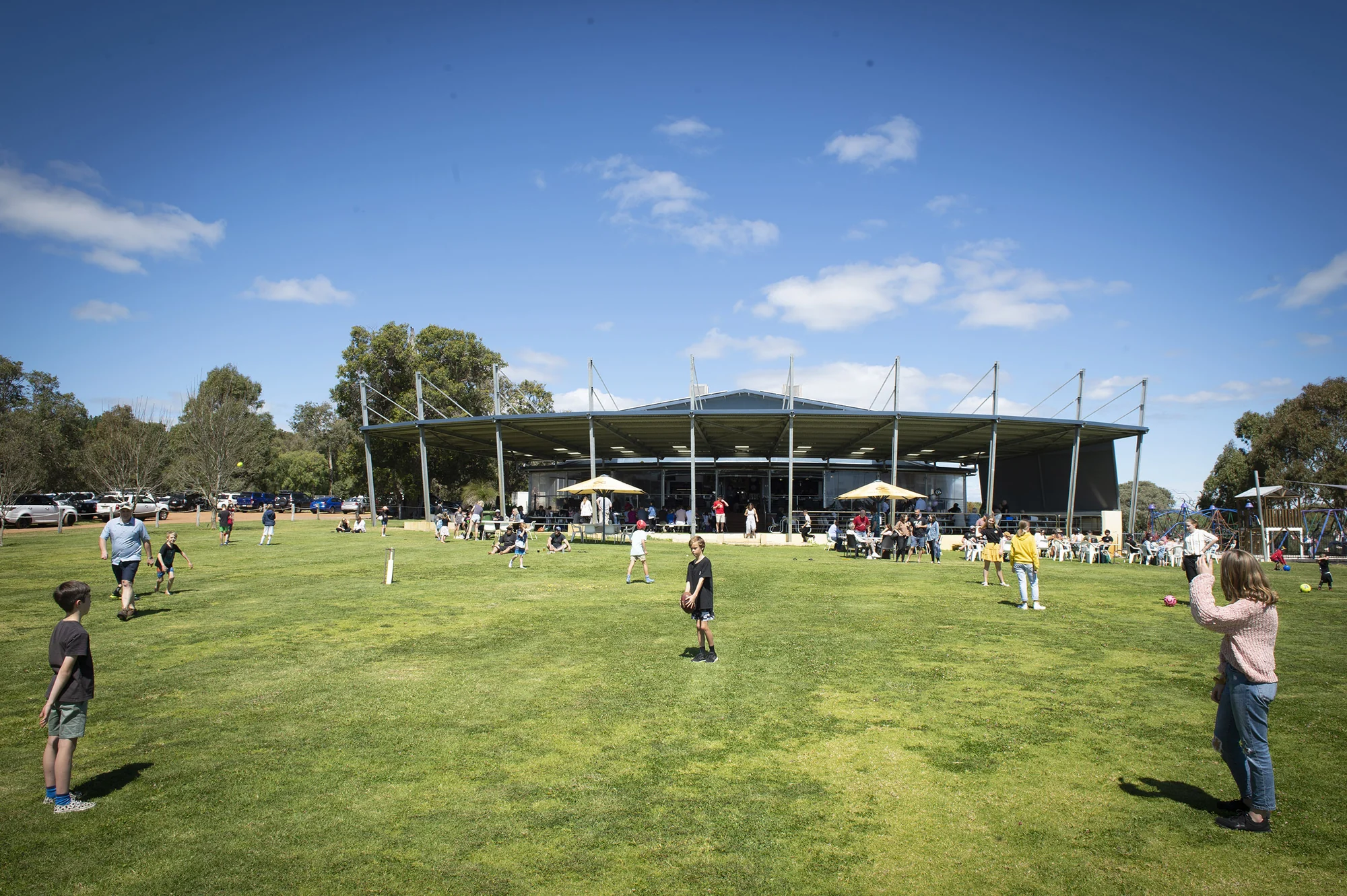 Children playing on the big oval while families enjoy the sunshine outside Old Coast Road Brewery