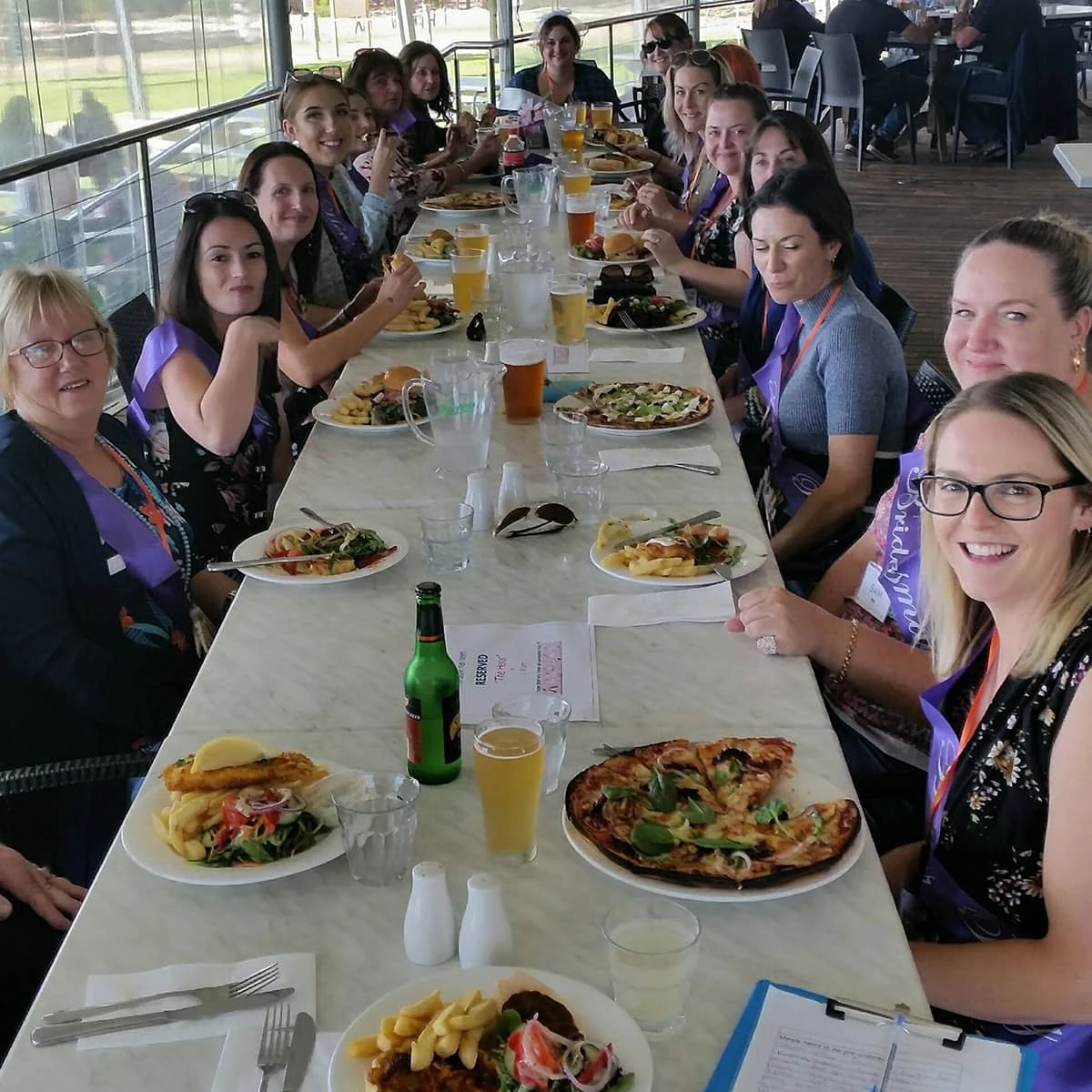 A group enjoying a long-table lunch on the protected deck.