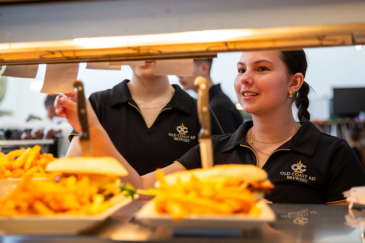 The Old Coast Road front-of-house team collecting meals at the kitchen pass
