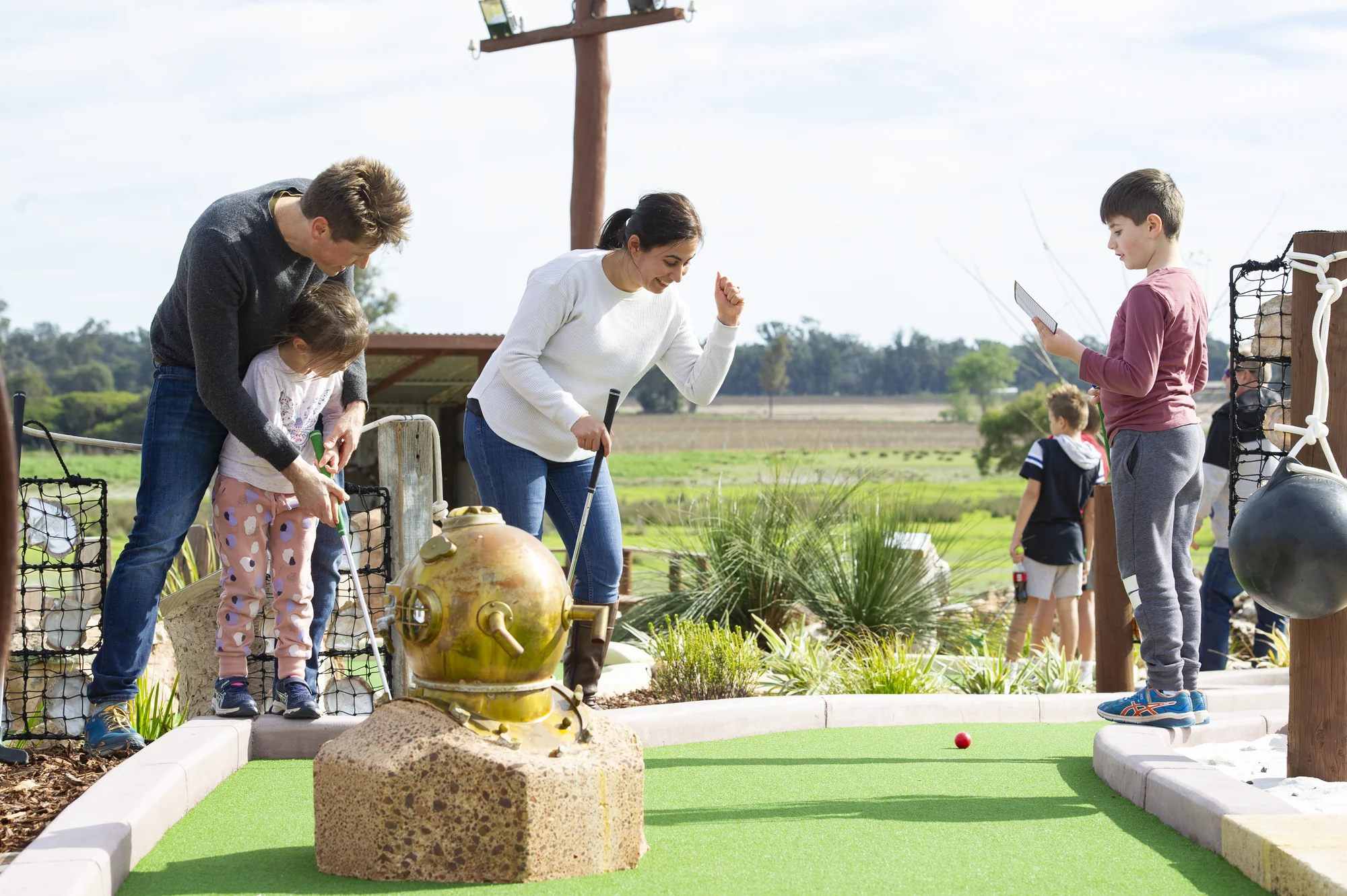 A family enjoying a round on the Old Coast Road mini-golf course
