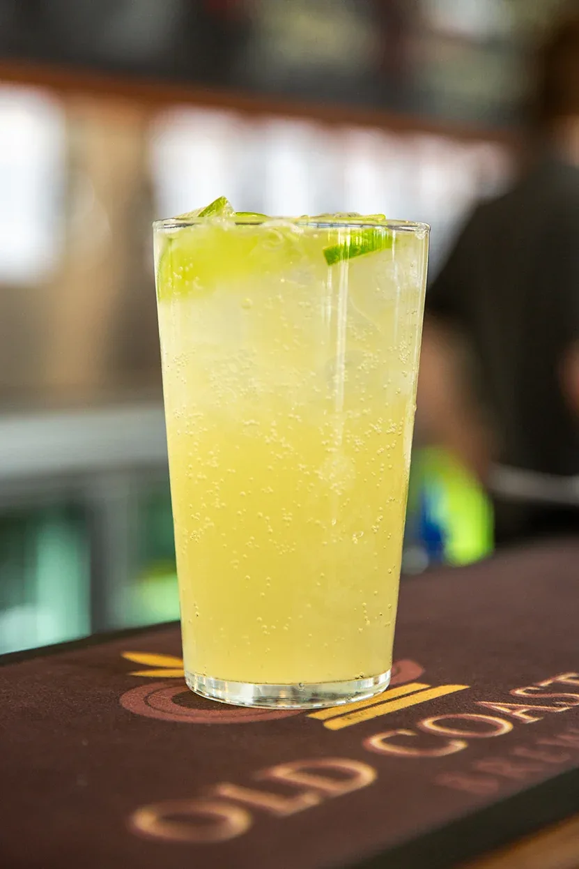 A tall drink garnished with fresh lime at the bar