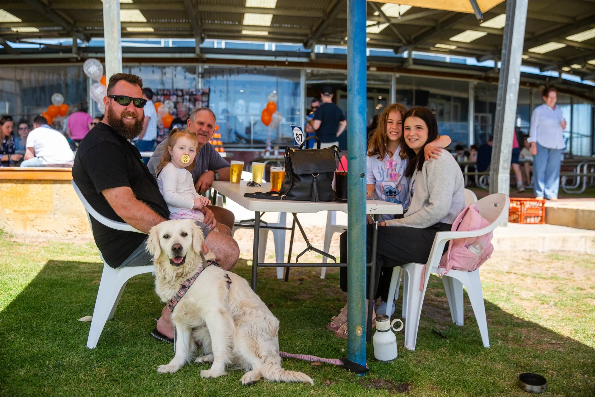 A family sharing a relaxed lunch outside Old Coast Road Brewery