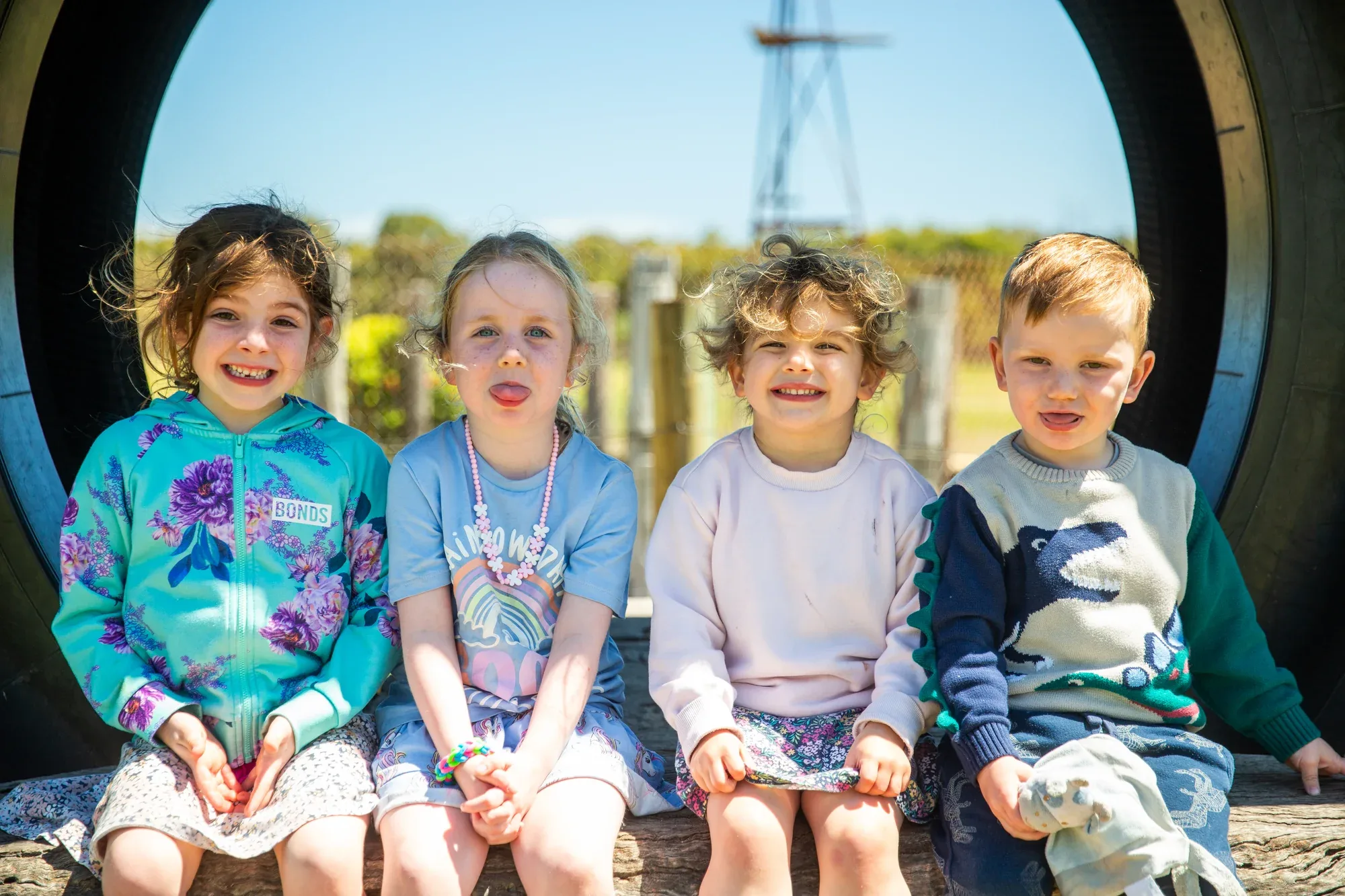 Four children sitting together in the mini-golf tyre feature